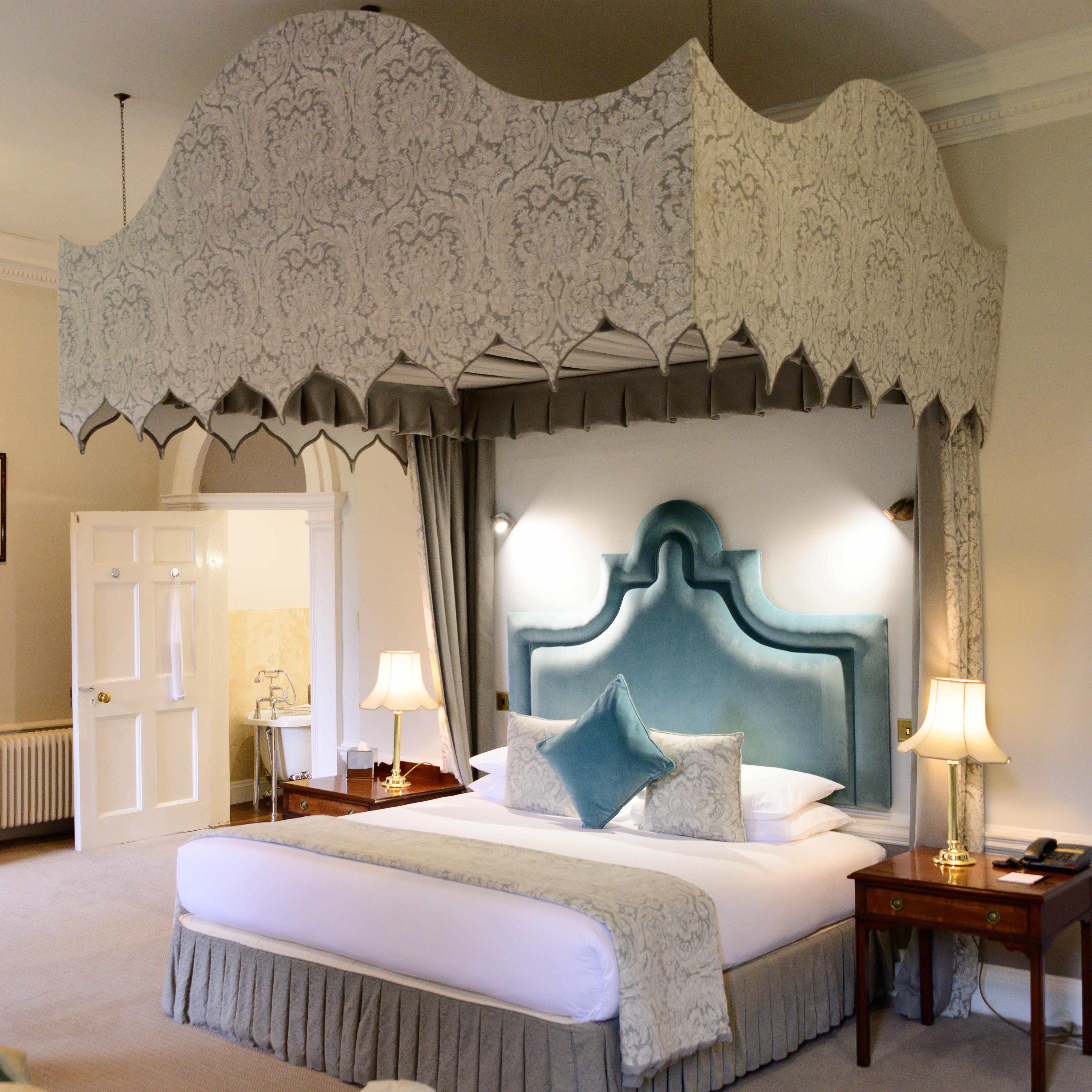Elegant hotel room with a canopy bed and classic decor