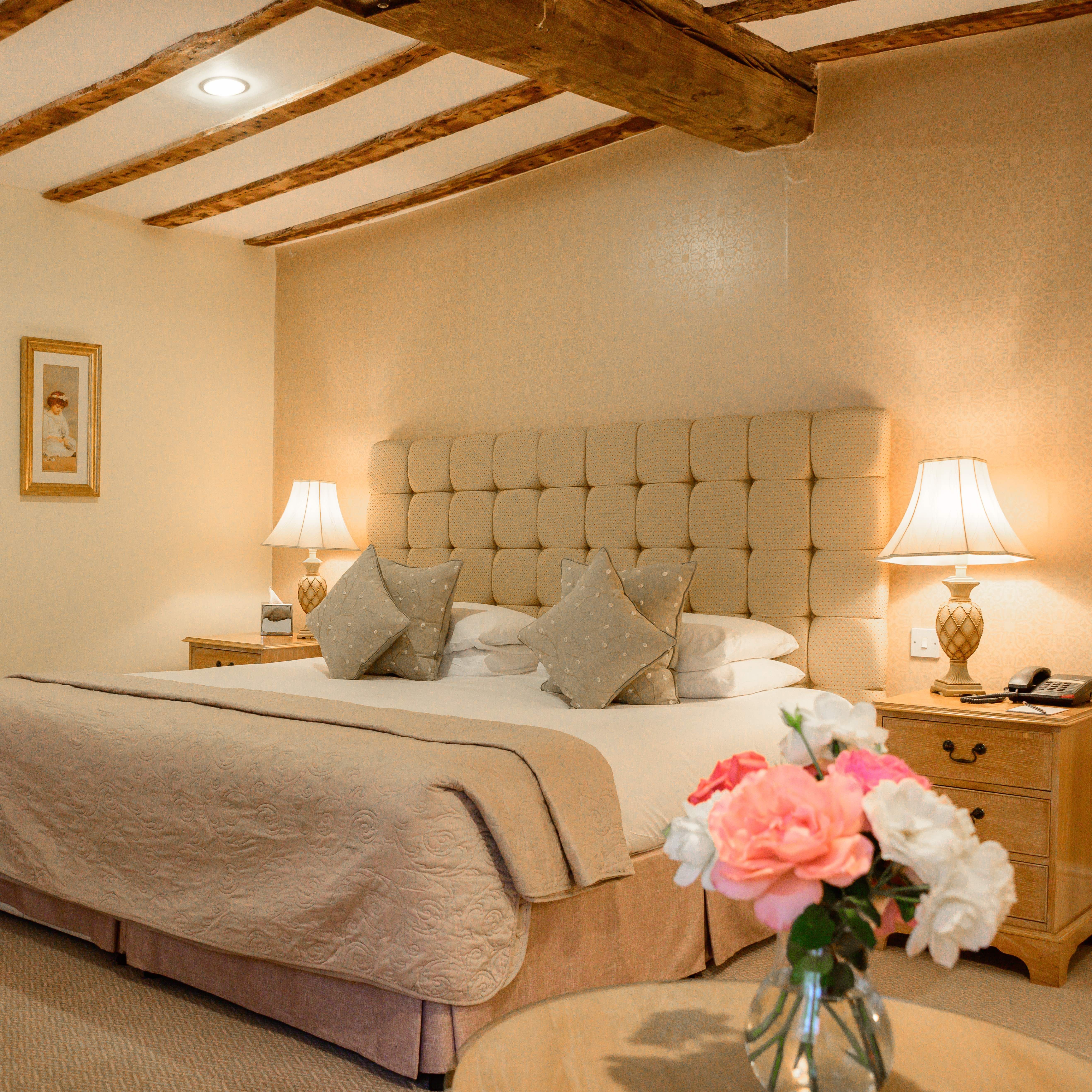 Cozy bedroom with large bed, floral pillows, and bedside lamps