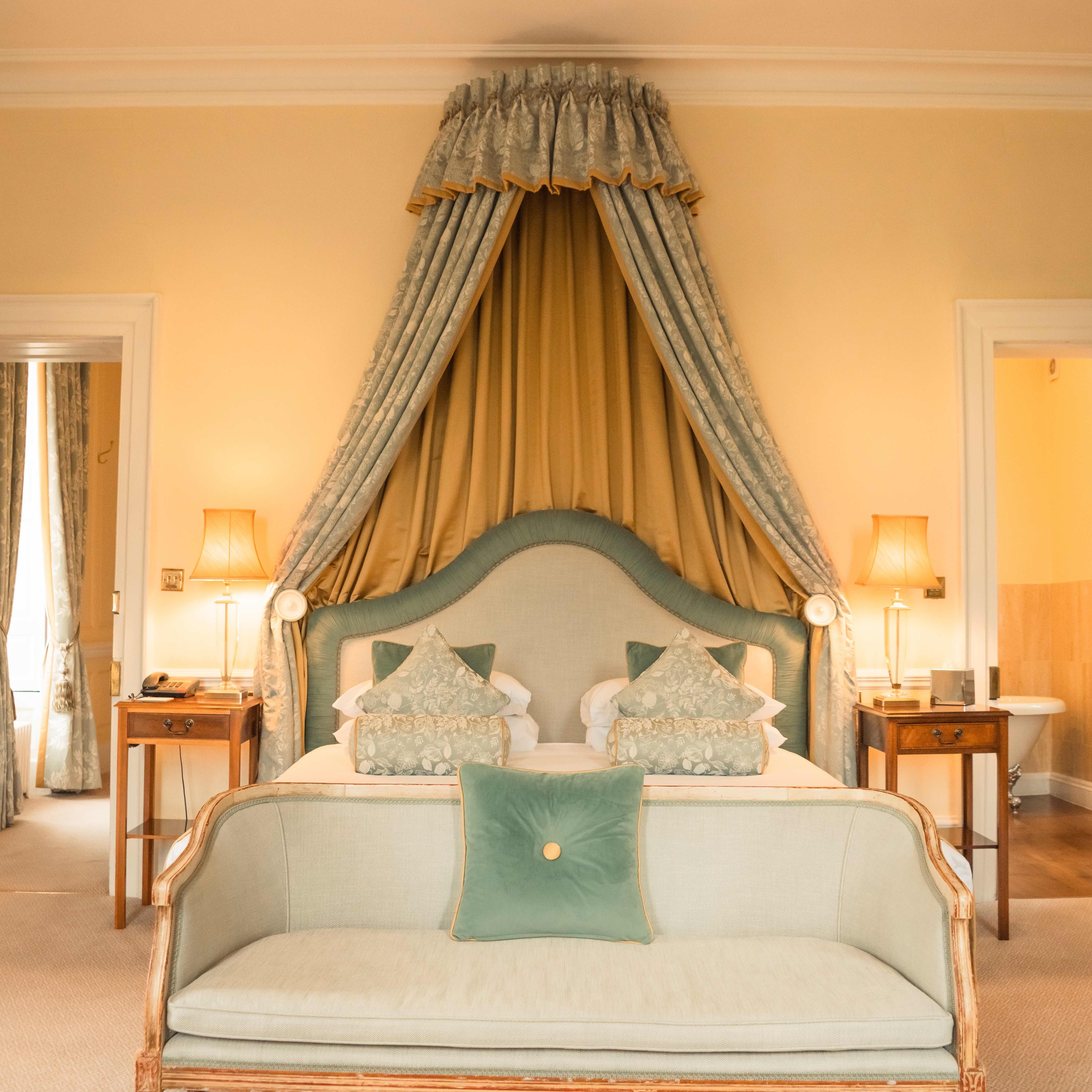 Elegant hotel room with canopy bed and vintage decor