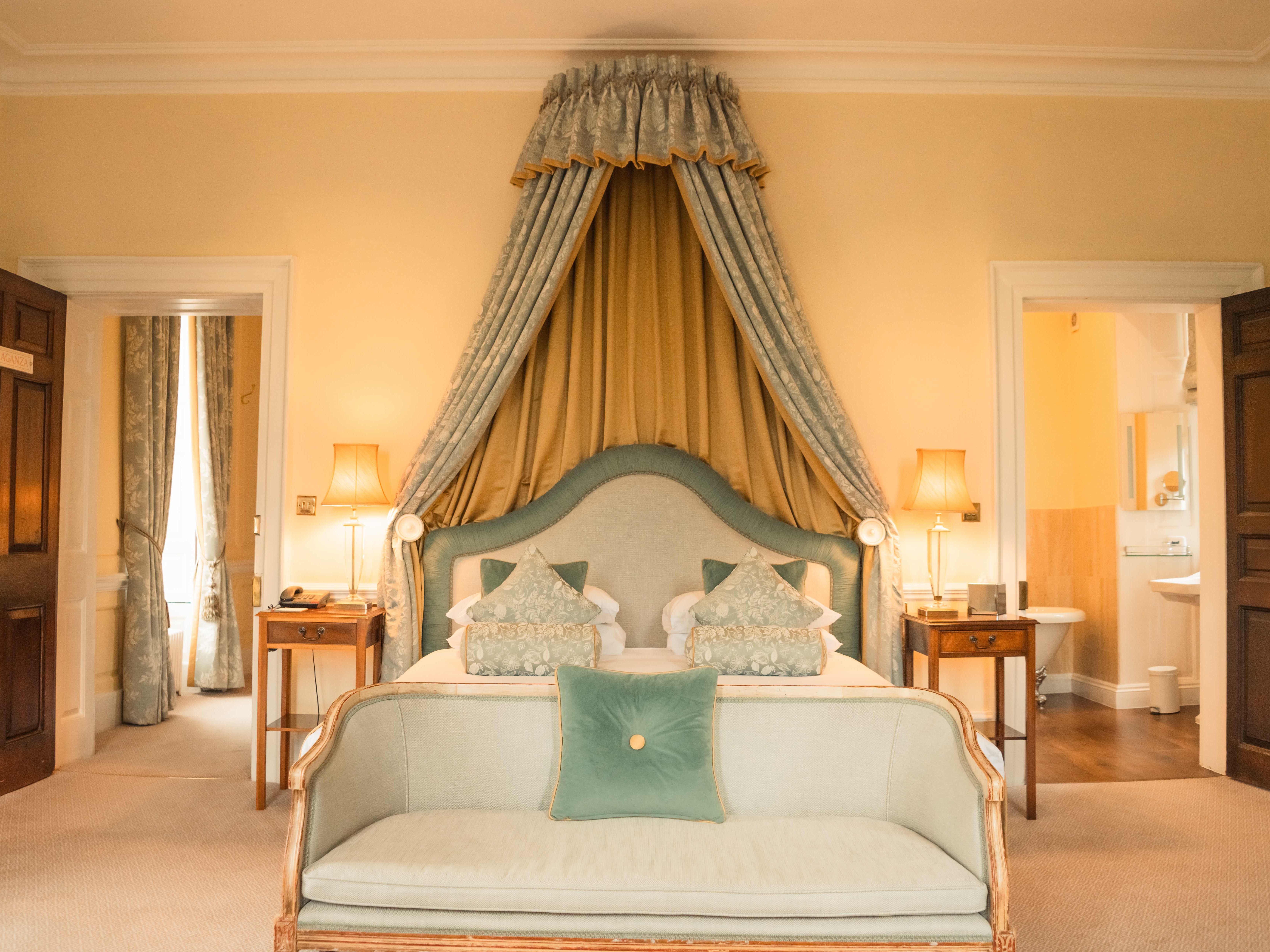 Elegant hotel room with canopy bed and vintage decor