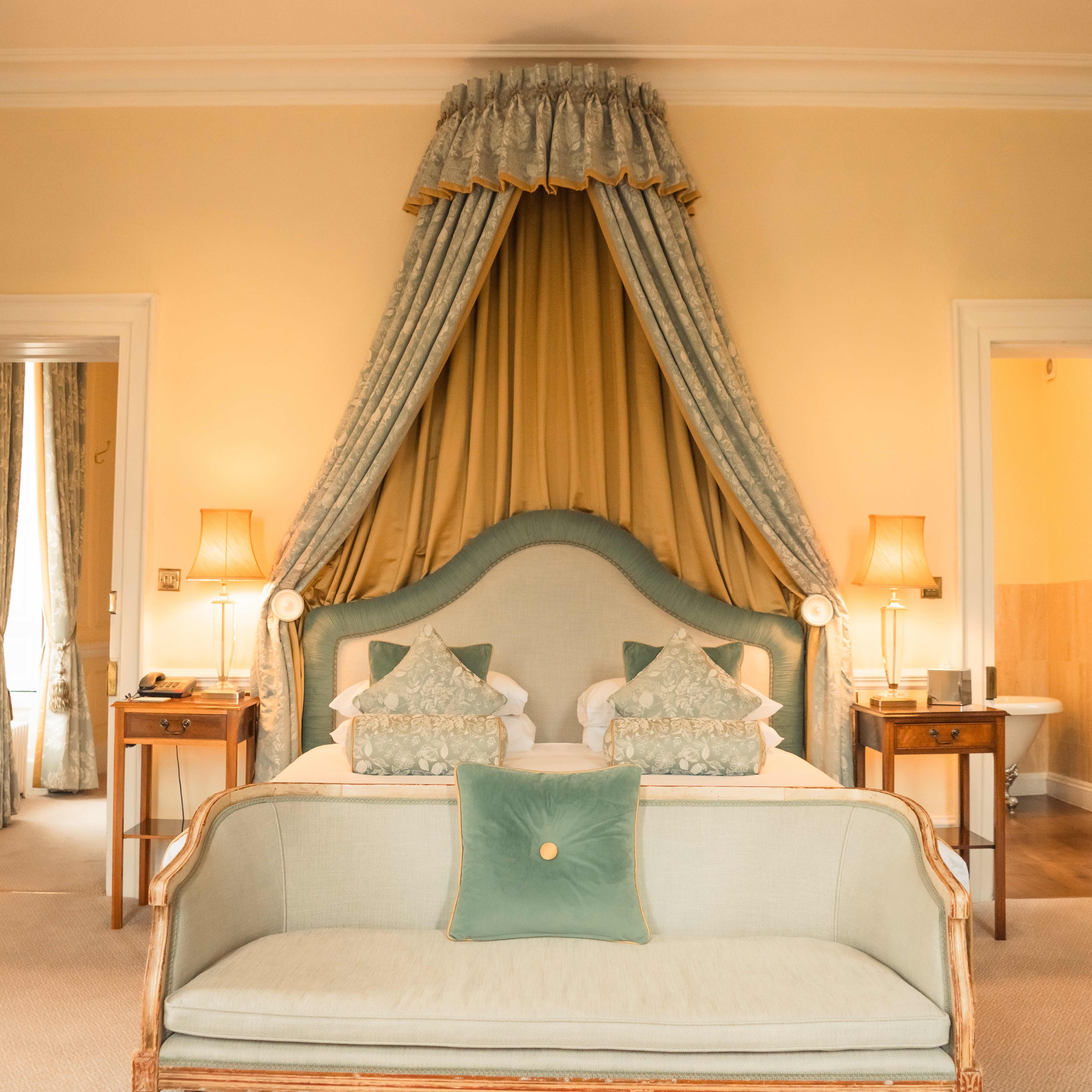 Elegant hotel room with canopy bed and vintage decor