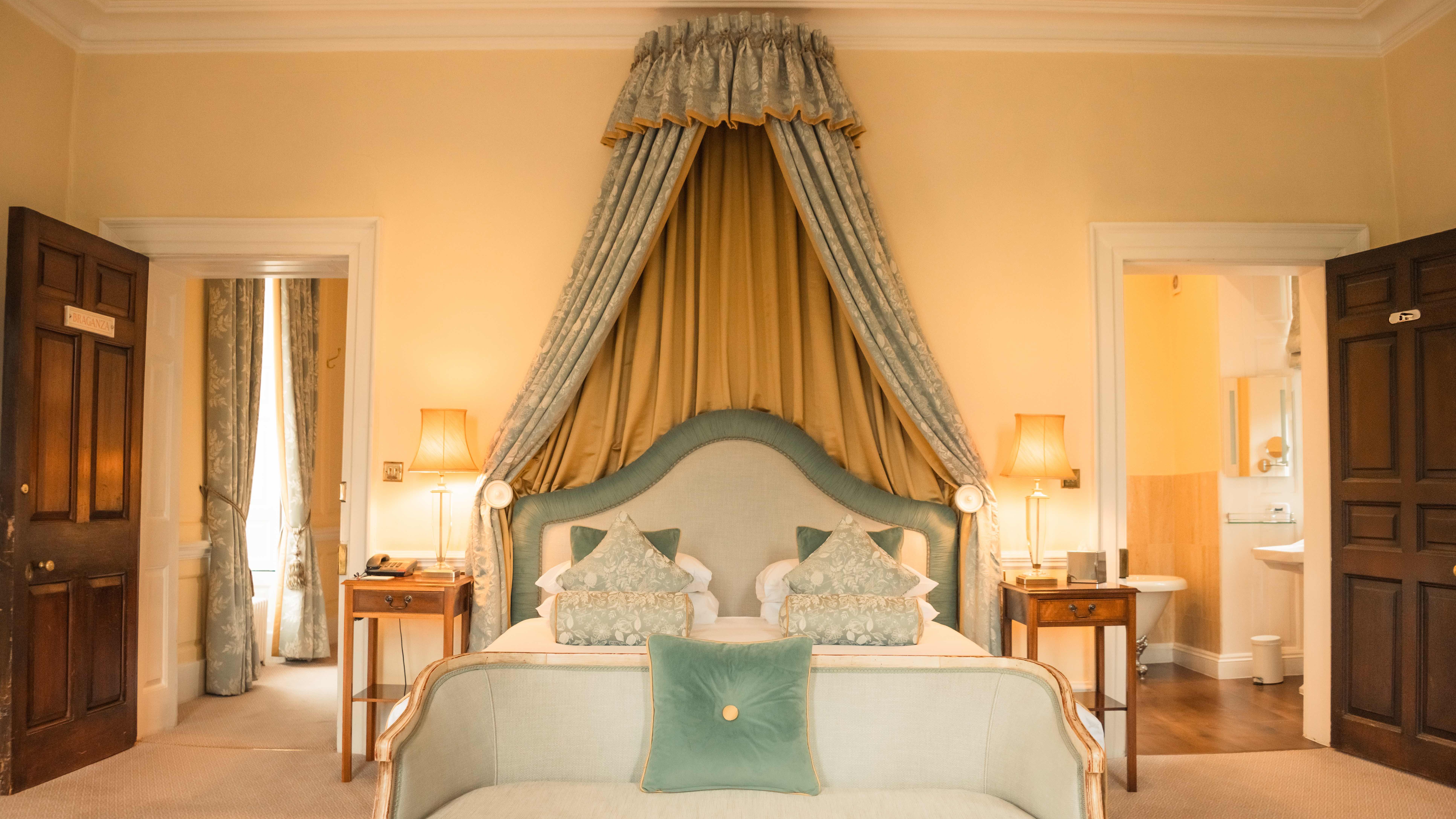 Elegant hotel room with canopy bed and vintage decor