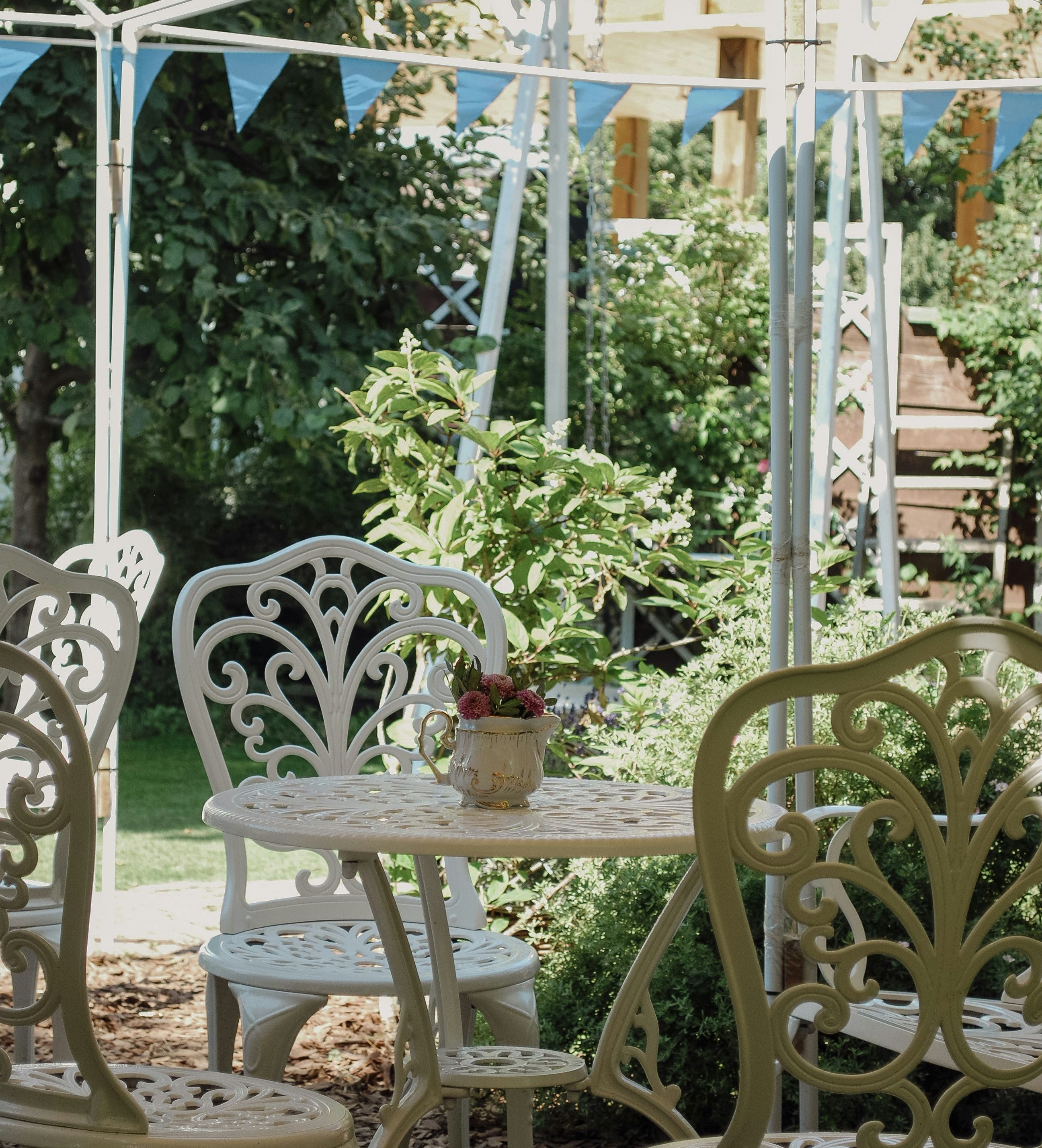 Garden Cafe with white outdoor table surrounded by plants