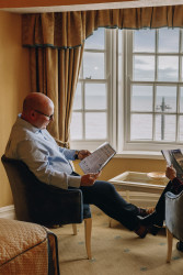 Guest reading magazine in window