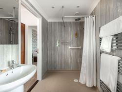 Accessible bathroom with walk-in shower, grab bars, and towel rack