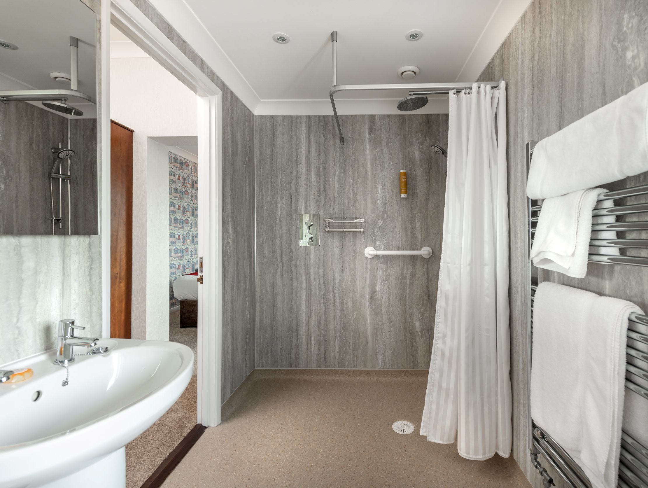 Accessible bathroom with walk-in shower, grab bars, and towel rack