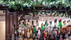 Bar shelf with various bottles of liquor and festive garland decoration