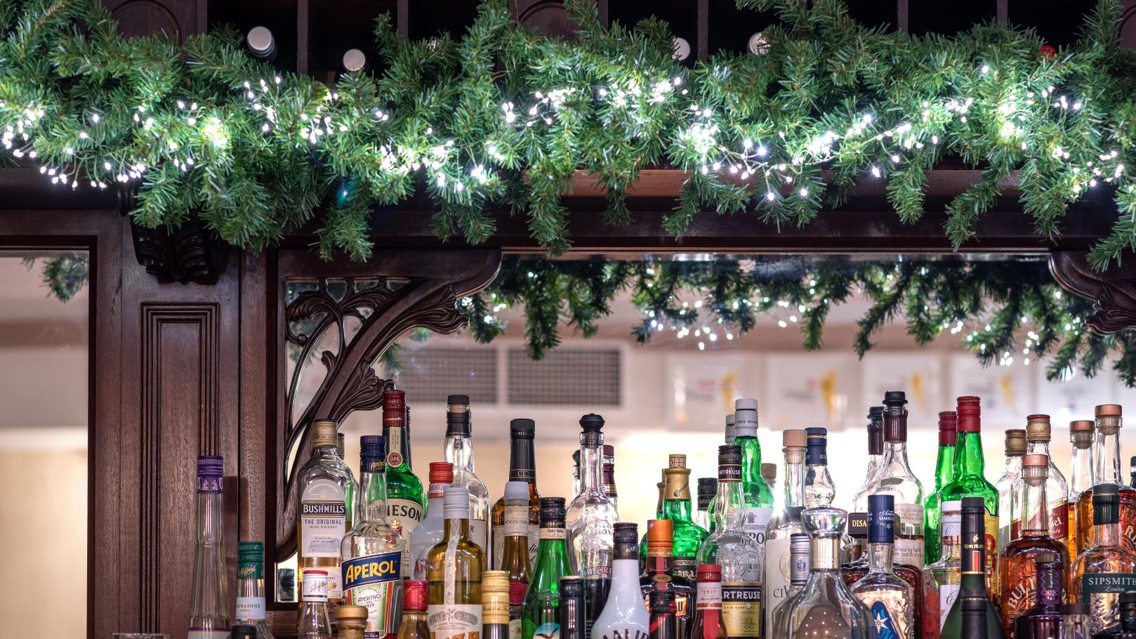 Bar with a variety of liquor bottles and festive garland with lights
