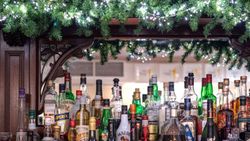 Bar with a variety of liquor bottles and festive garland with lights