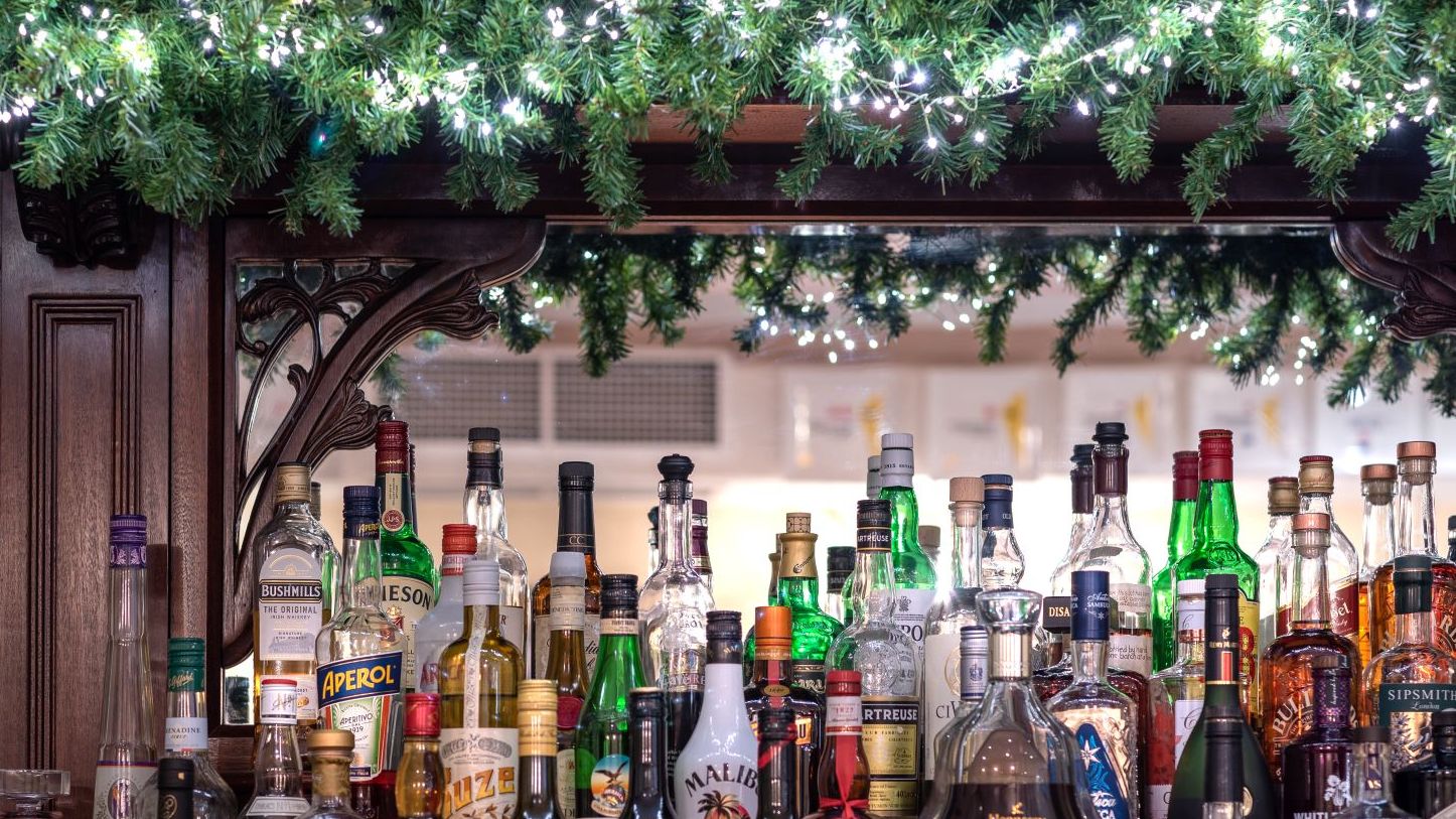 Bar with a variety of liquor bottles and festive garland with lights