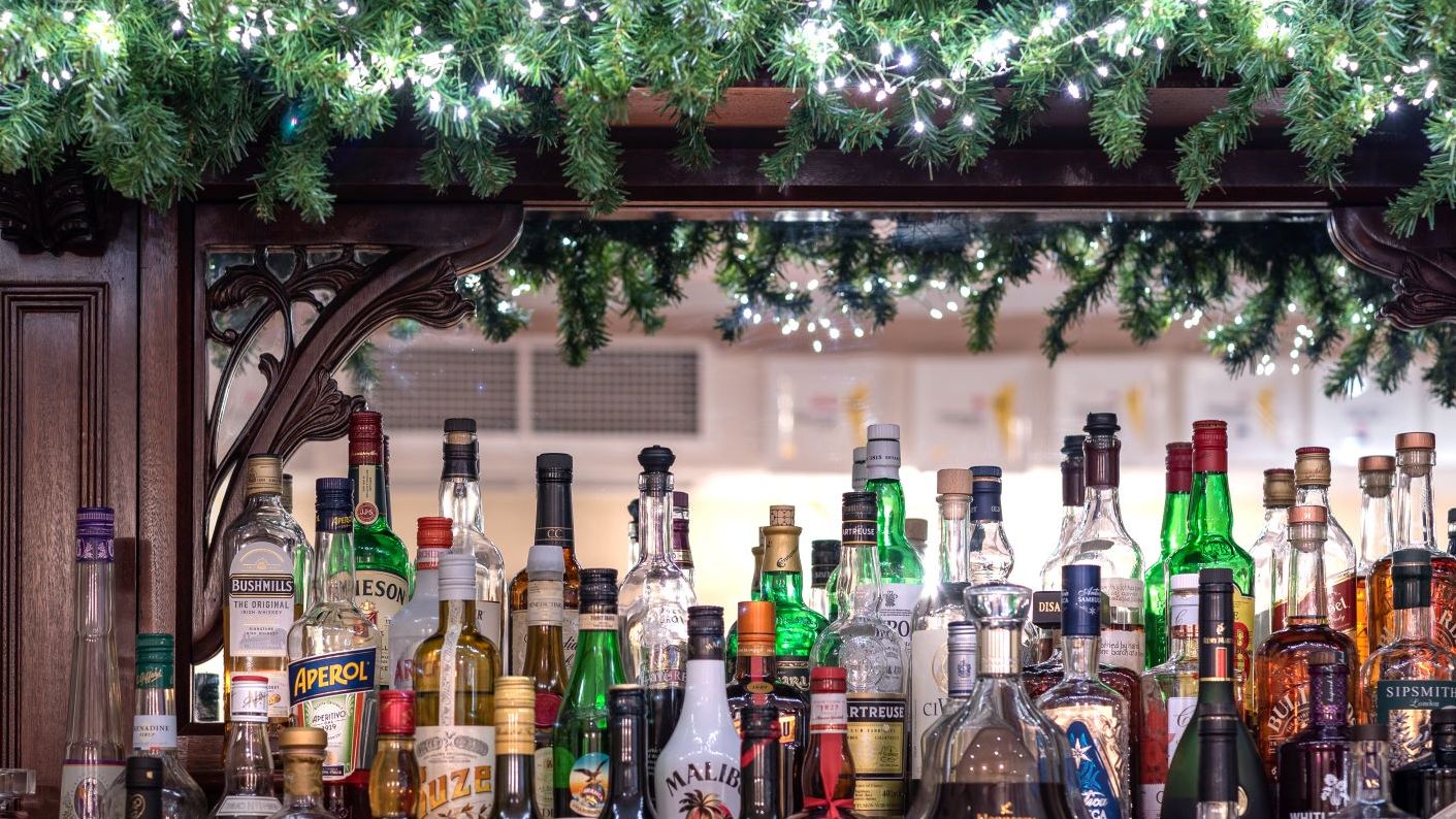 Bar with a variety of liquor bottles and festive garland with lights