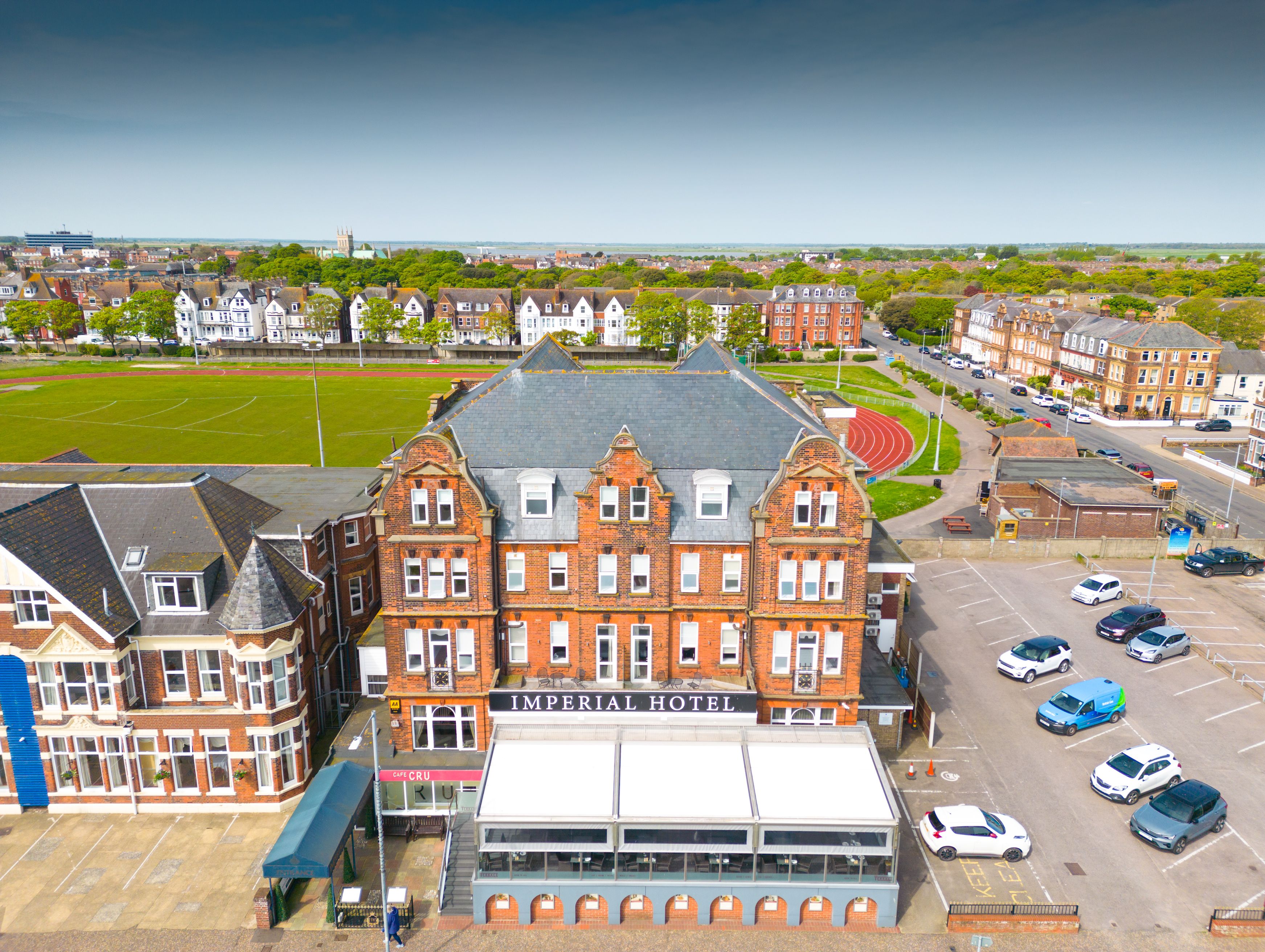 Aerial view of the Imperial Hotel with adjacent parking and nearby sports field.