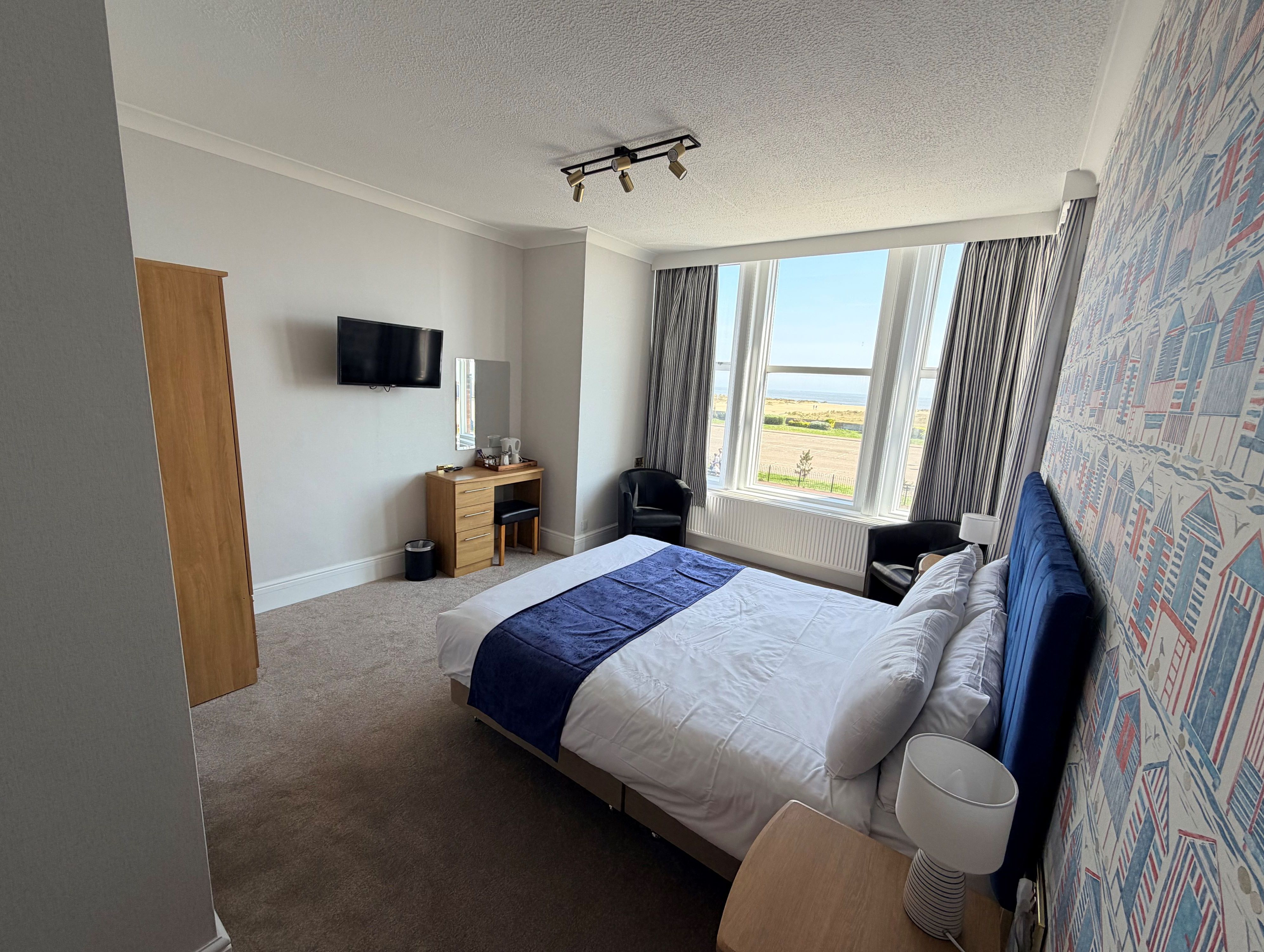 Bright sea view bedroom at Imperial Lodge, Great Yarmouth, with double bed, large bay window and chairs
