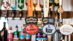 Close-up of beer and cider pumps at a bar with labels for Lacons Encore, Lacons LGR, and Aspall Draught Cyder.