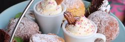 Close-up of assorted desserts on a tiered serving tray, including scones, cupcakes, shortbread, brownies, and cream-topped treats.