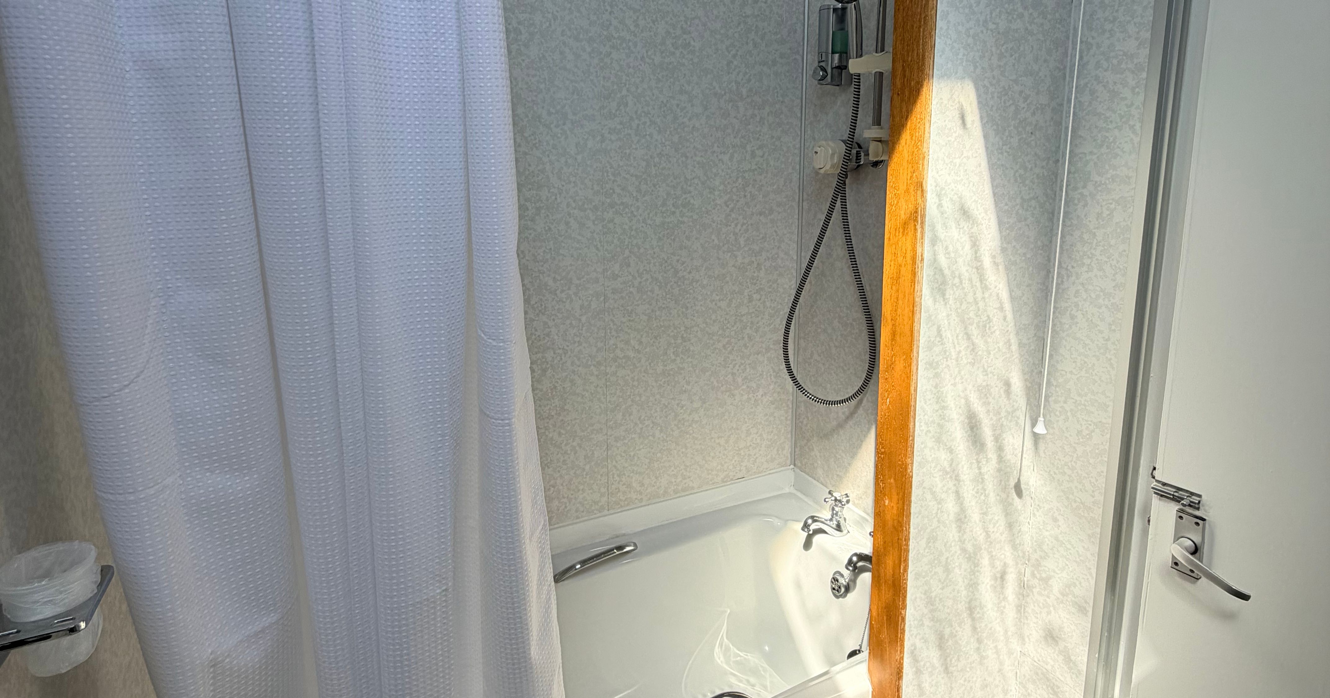 Compact lodge bathroom with bathtub and shower curtain