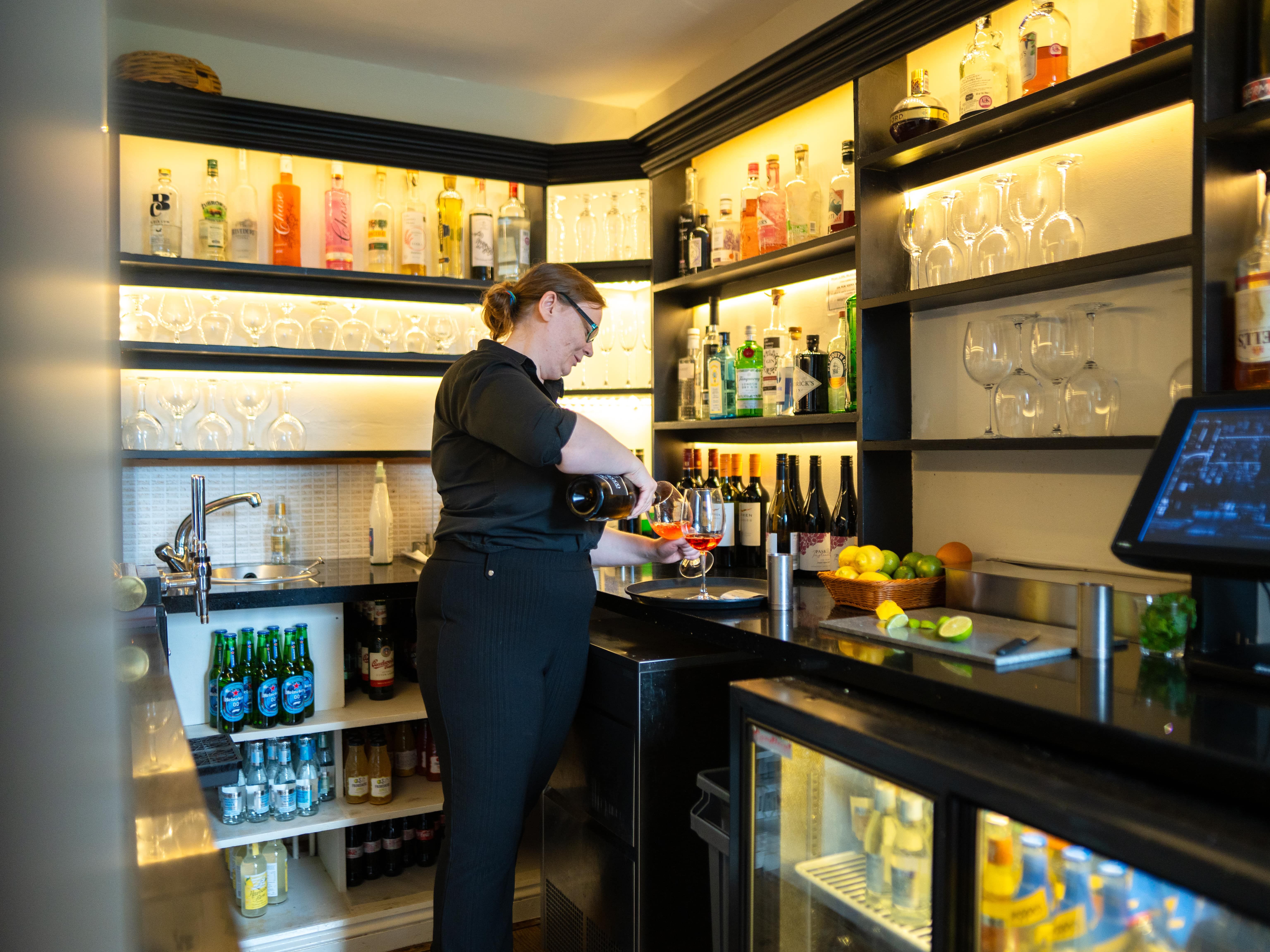 Lady pouring glass of wine in Bar Area
