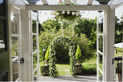 Grass archway seen through open glass doors