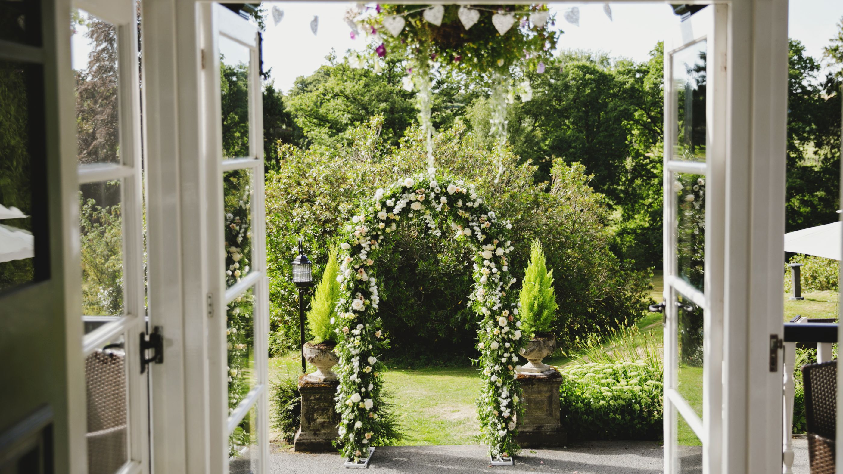 Grass archway seen through open glass doors