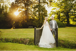 Bride and groom stood outside in front of sunset