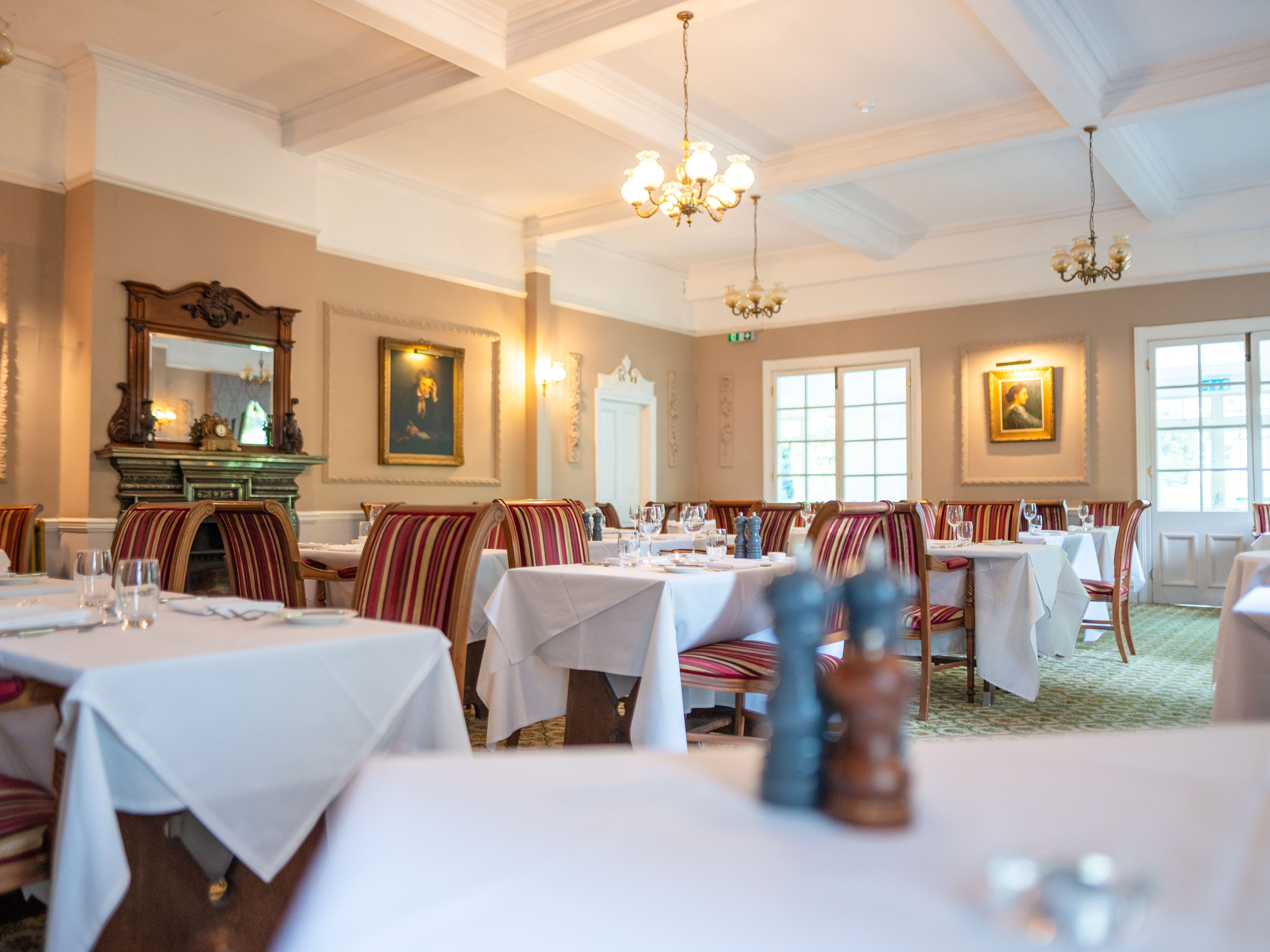 Dining tables laid out with white clothes and glasswear