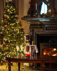 Christmas tree next to a burning fireplace