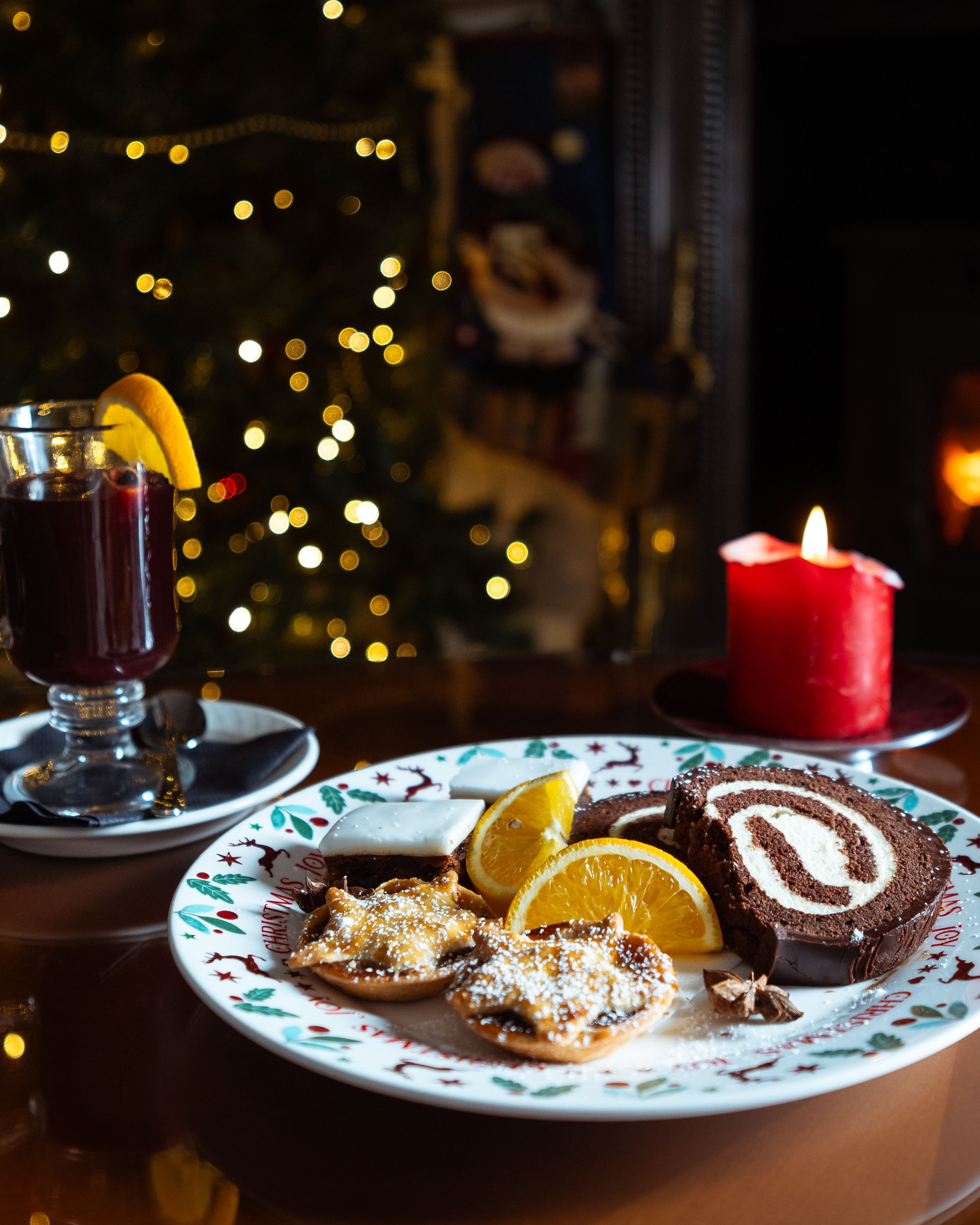 Plate filled with Christmas treats and a glass of mulled wine