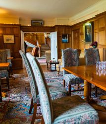 Table and chairs in wood panelled room and carpet