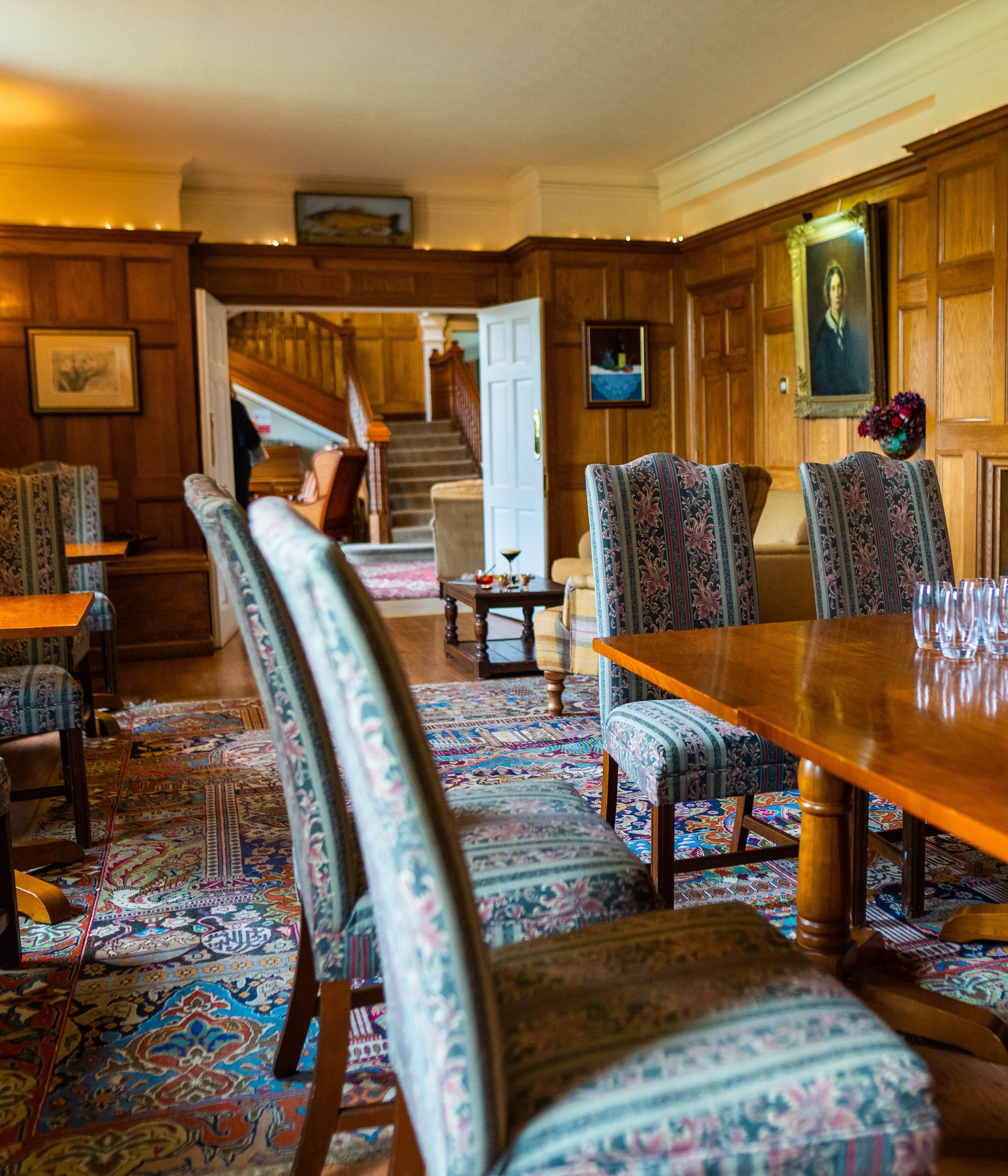 Table and chairs in wood panelled room and carpet