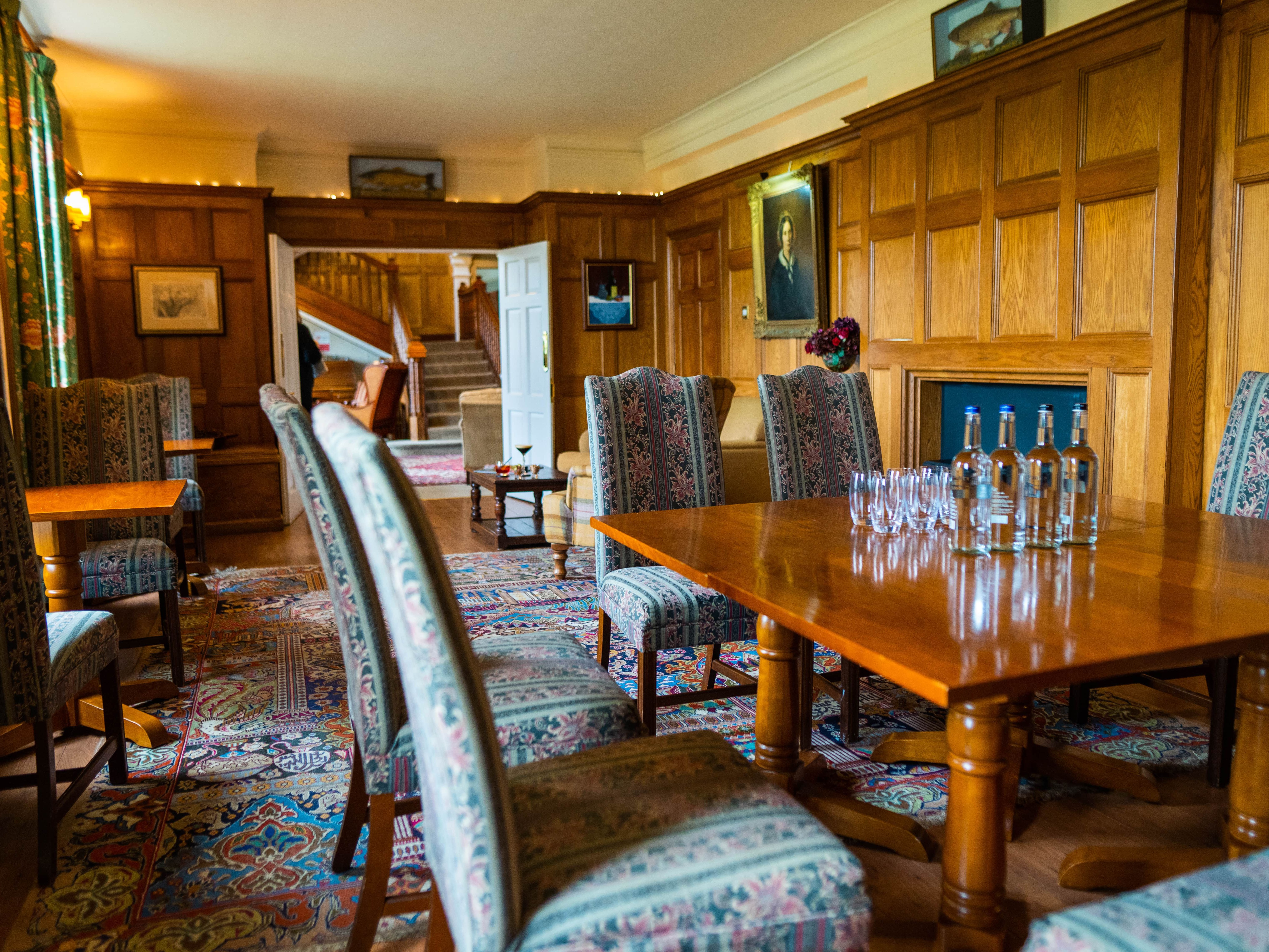 Table and chairs in wood panelled room and carpet