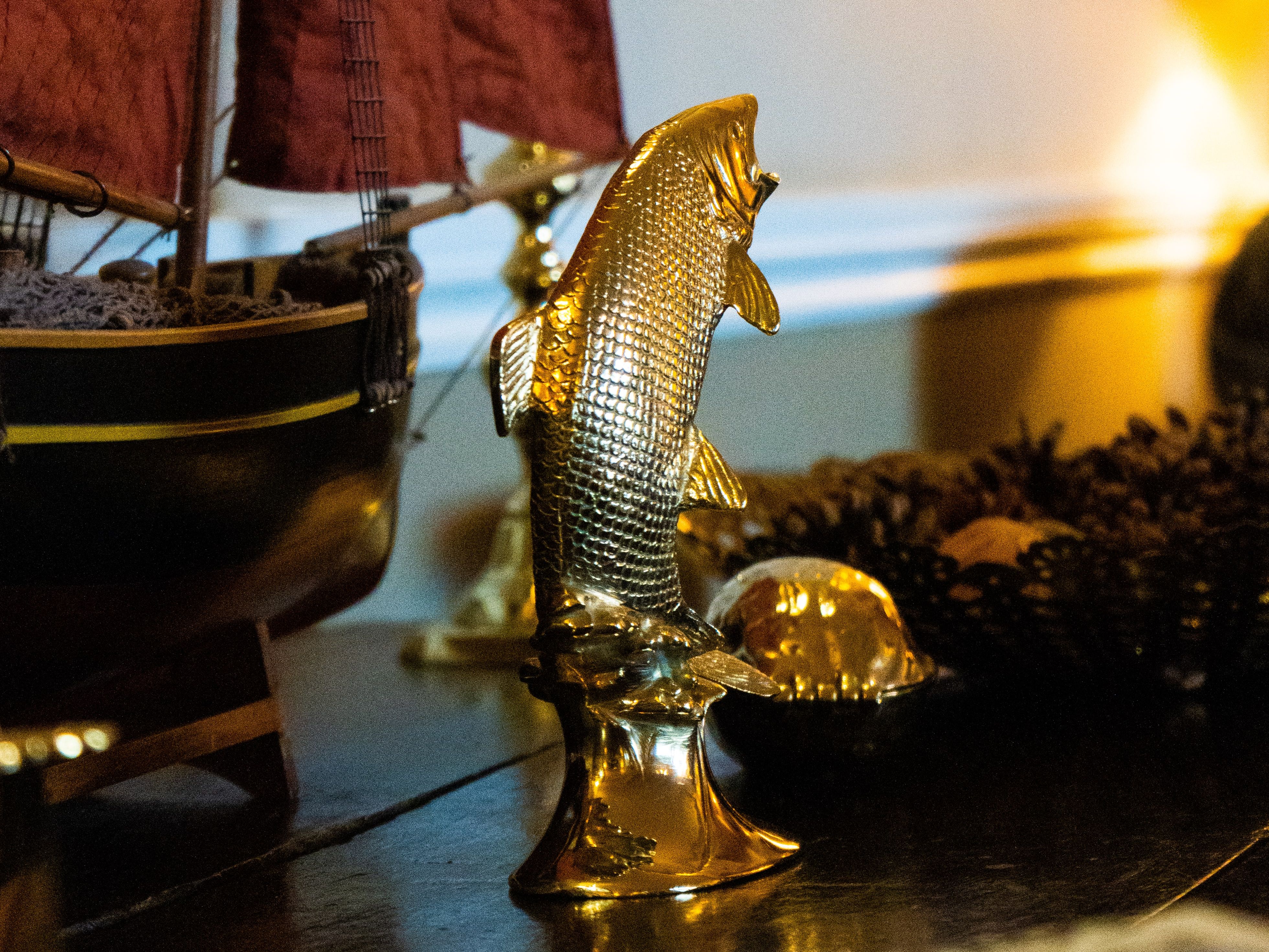 Toy boat next to a gold steel fish