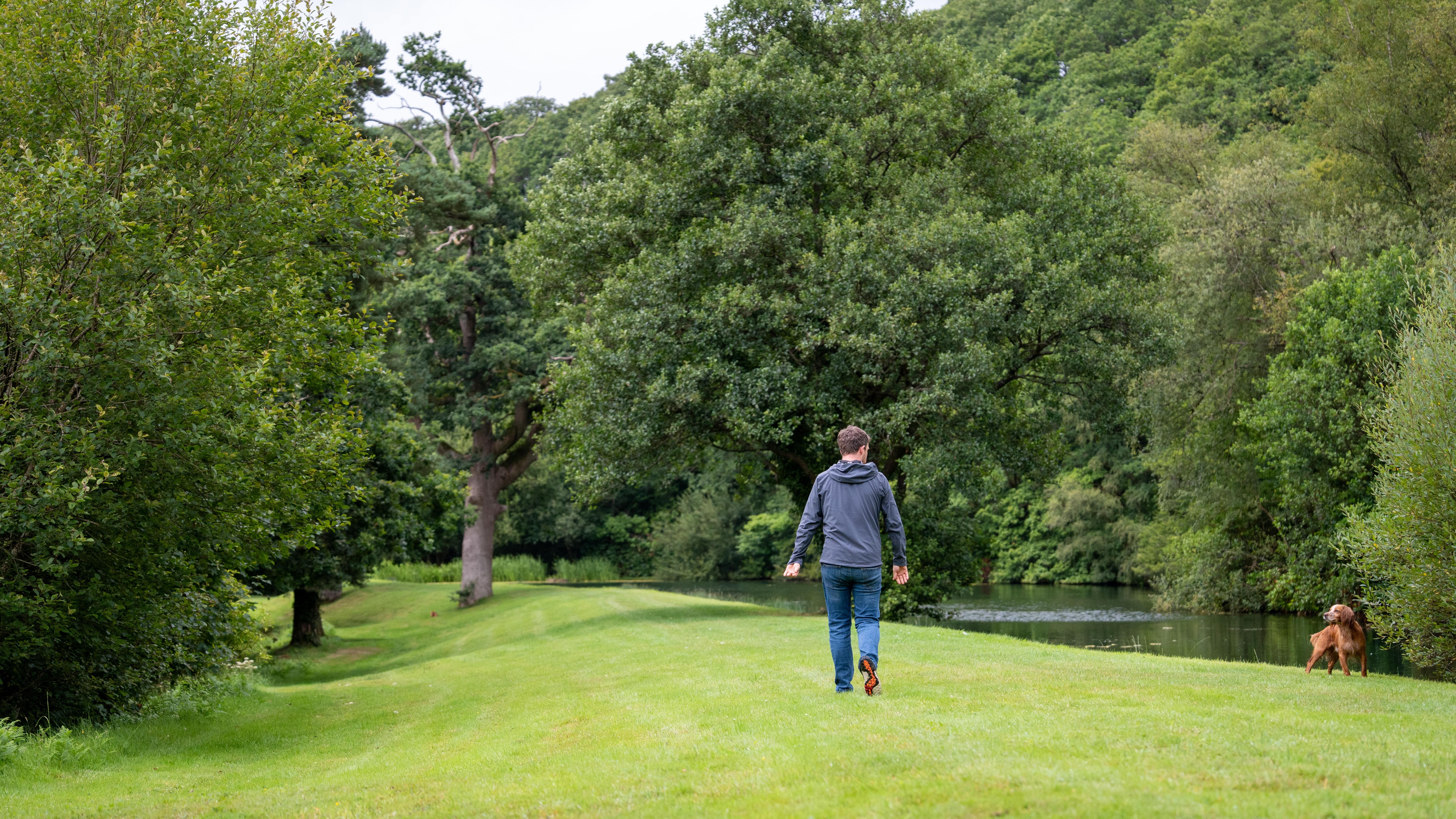 Man walking dog next to river