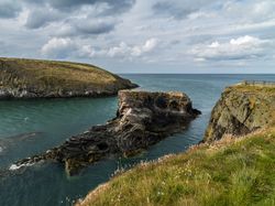 Welsh coastline with grassy rocks and blue sea