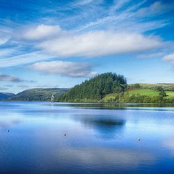 Welsh reservoir with large body of water against green grass
