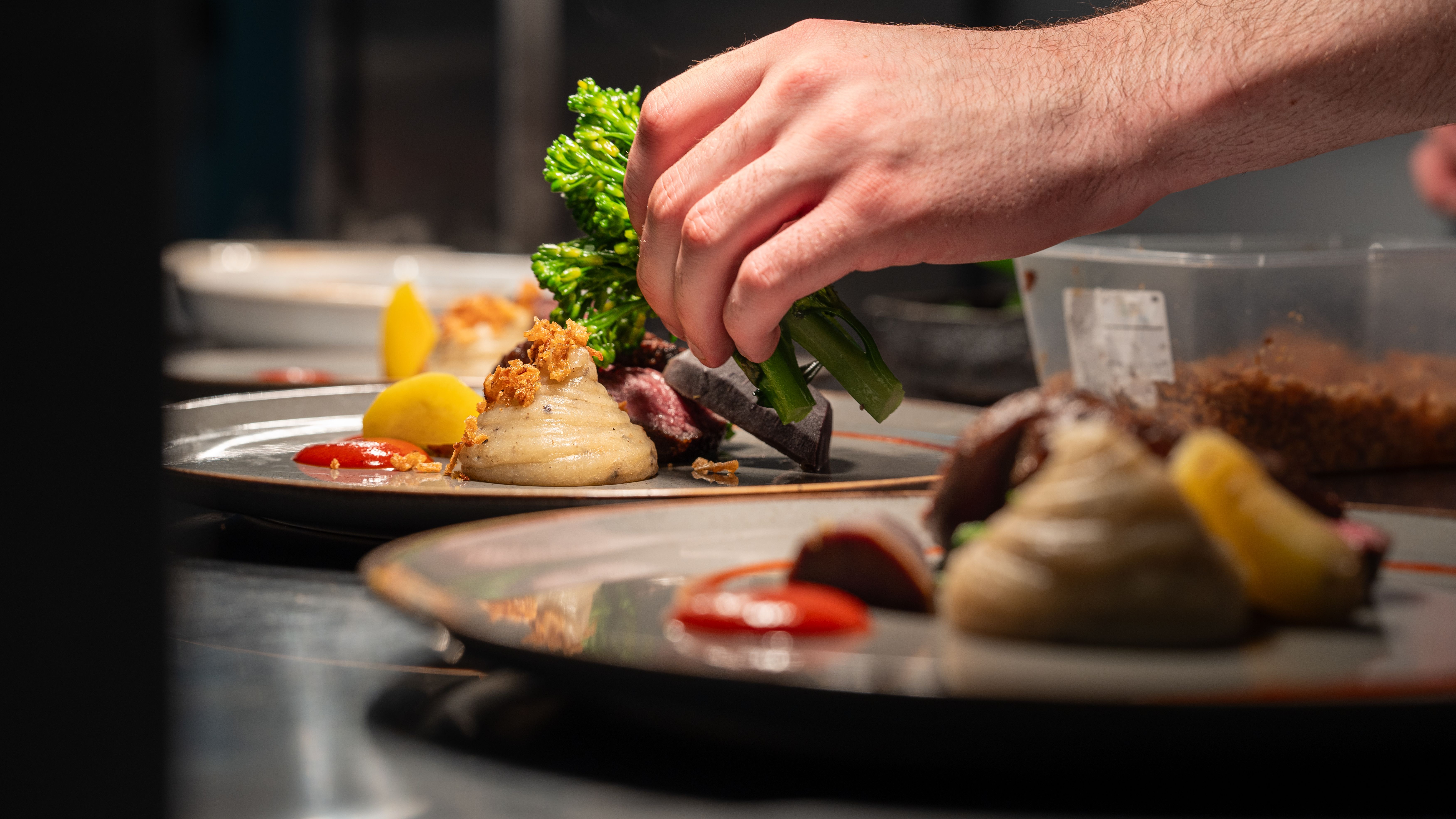 Two plates of food being assembled