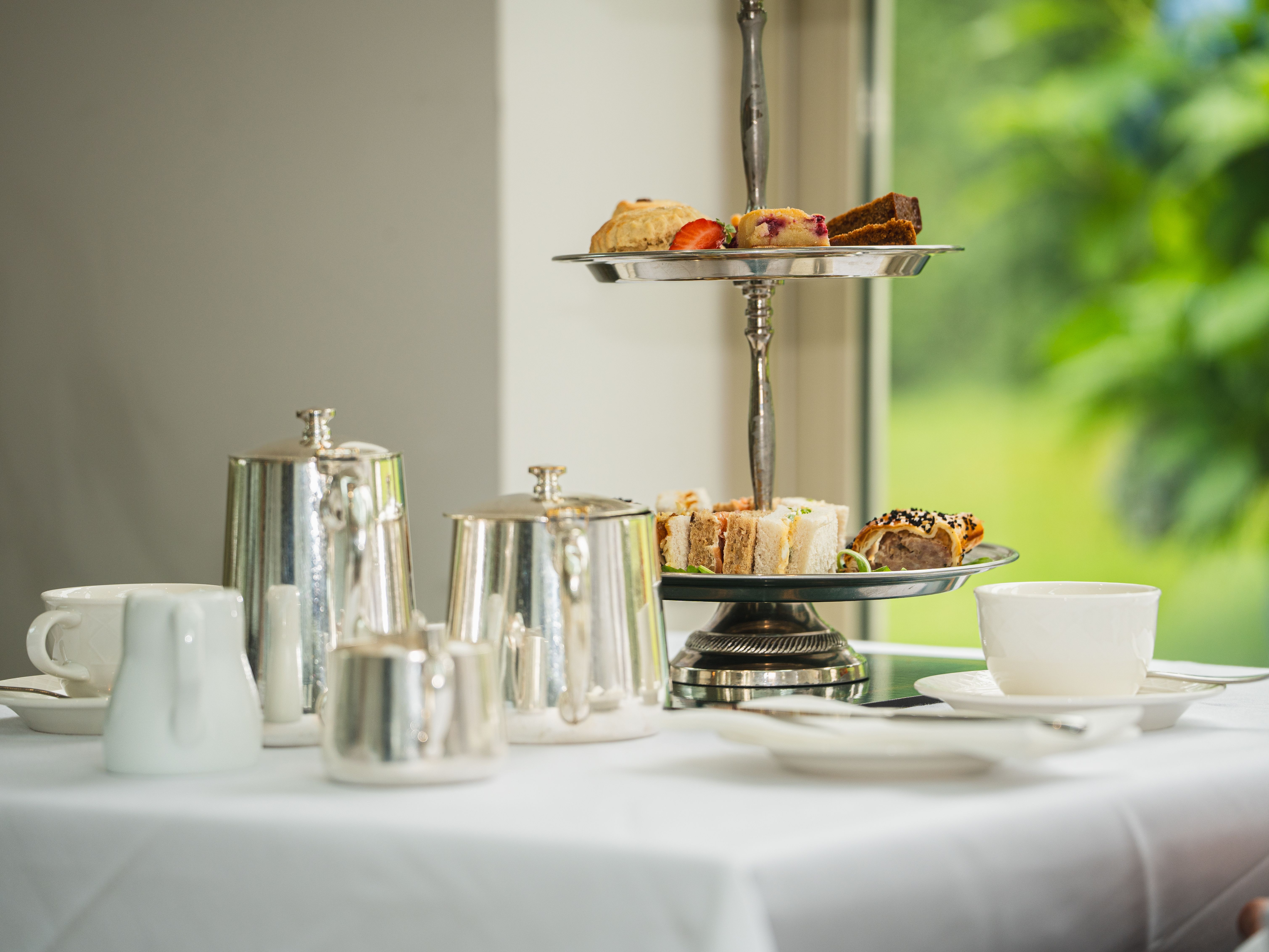 Cake stand next to silver tea set