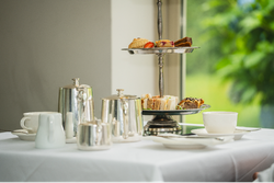 Cake stand next to silver tea set