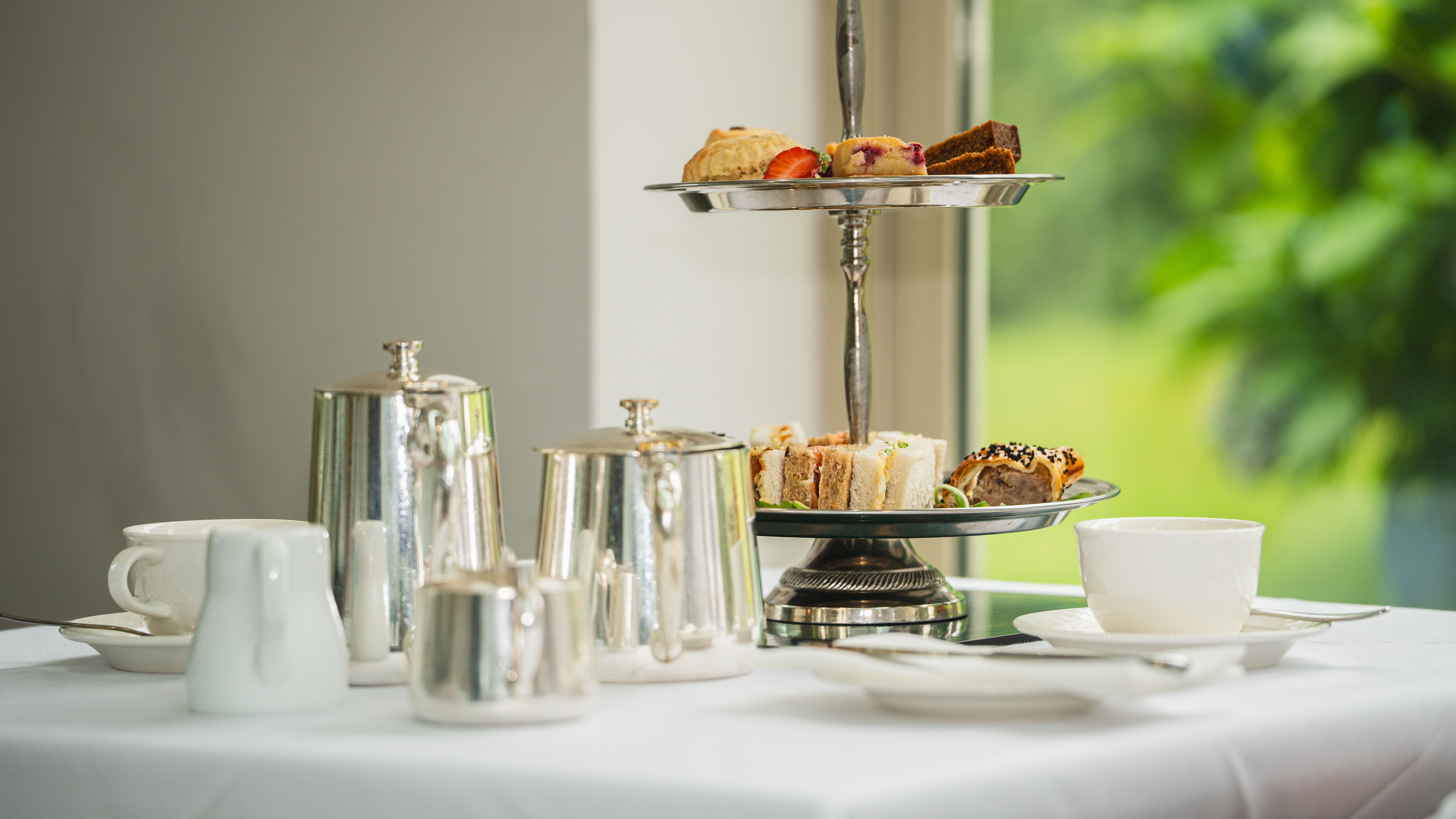 Cake stand next to silver tea set