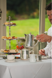 Cake stand next to silver tea set