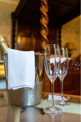 Two champagne glasses next to a cooler in bedroom