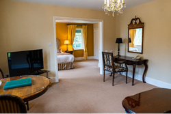 Seating area with TV looking into bedroom through archway
