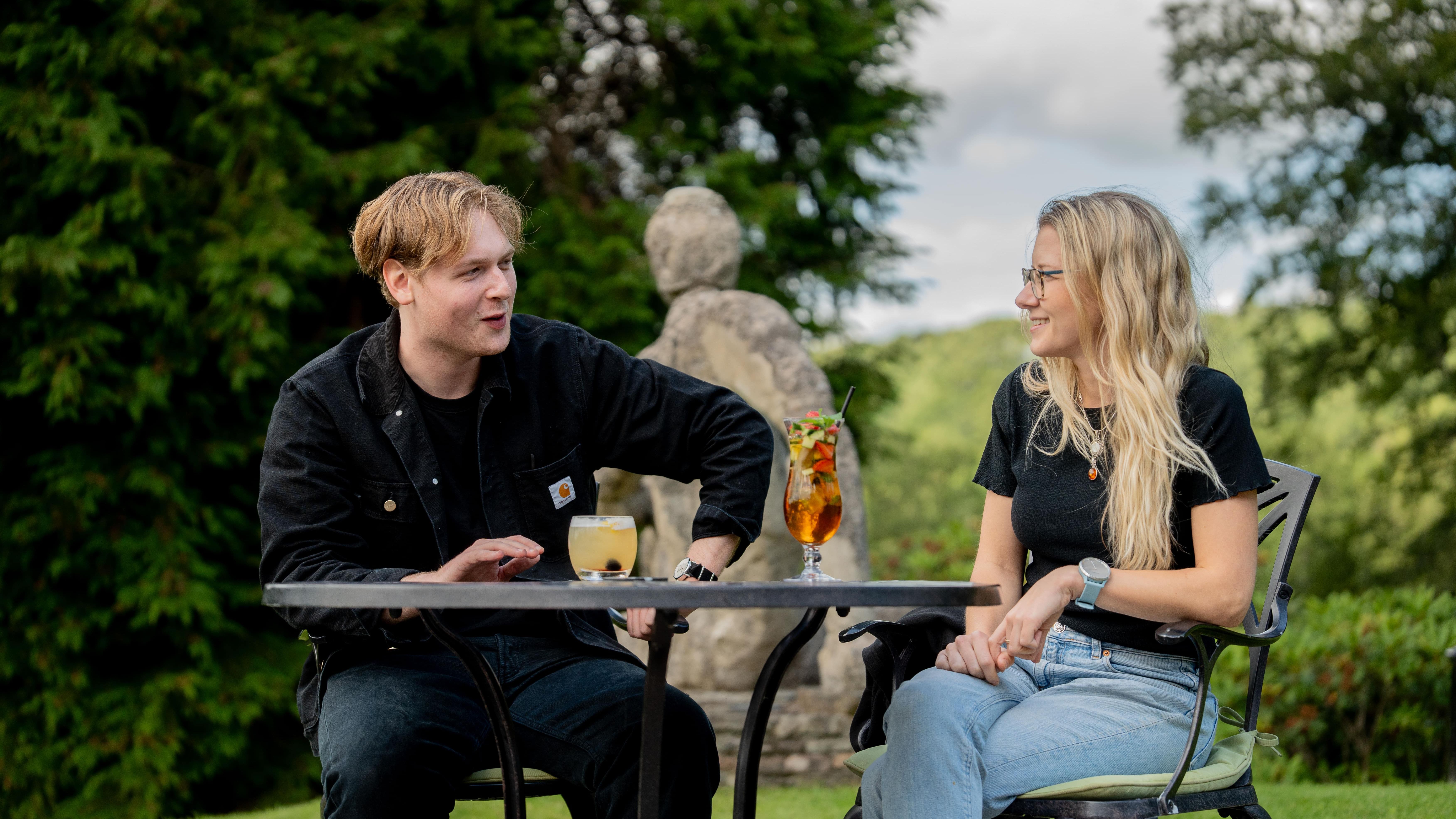 Two people drinking refreshing drinks and laughing