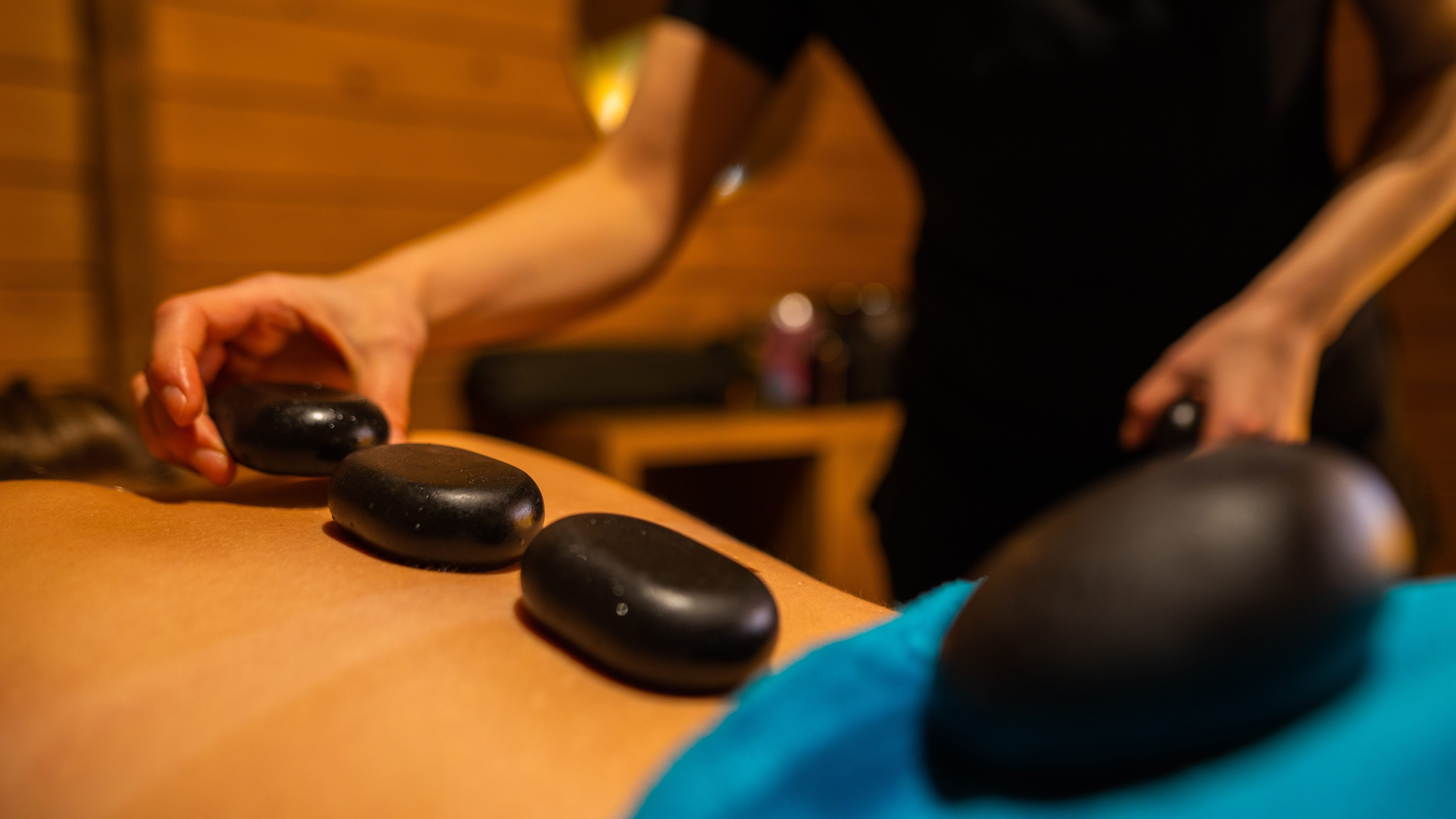 Lady Having a hot stone massage in the spa