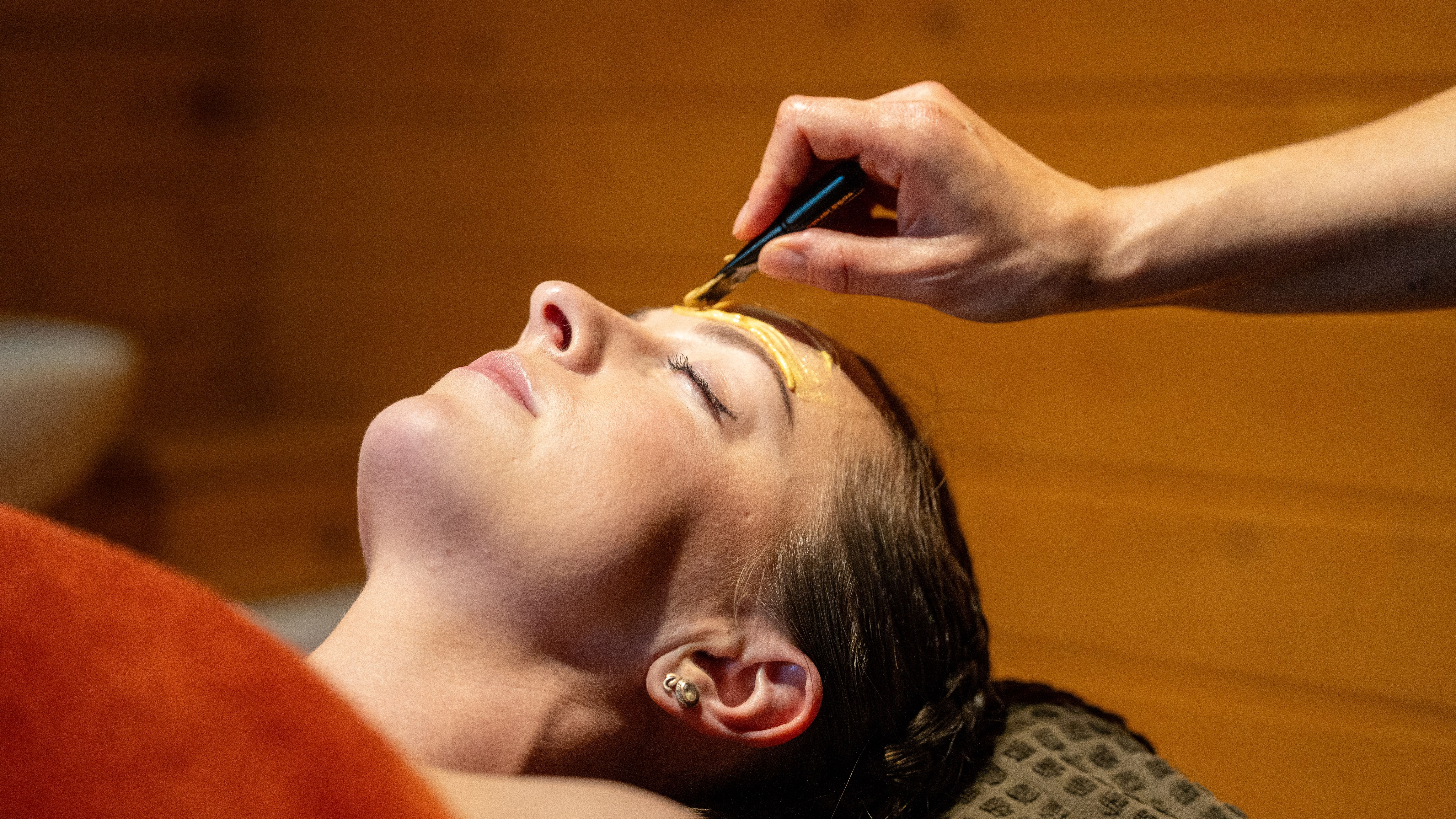 A lady lying down receiving a facial treatment