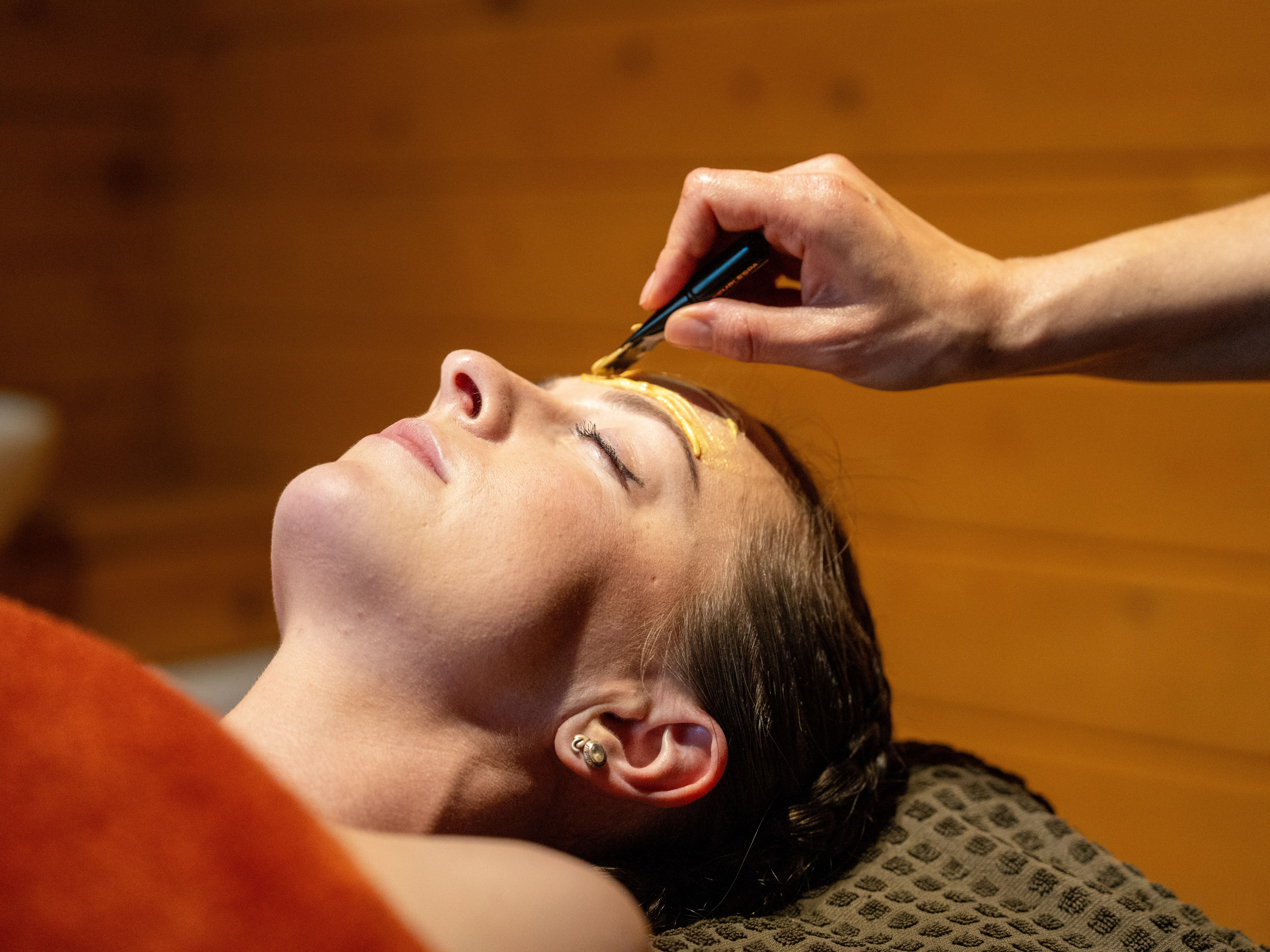 A lady lying down receiving a facial treatment