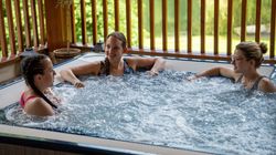 Three ladies laughing together in a hot tub