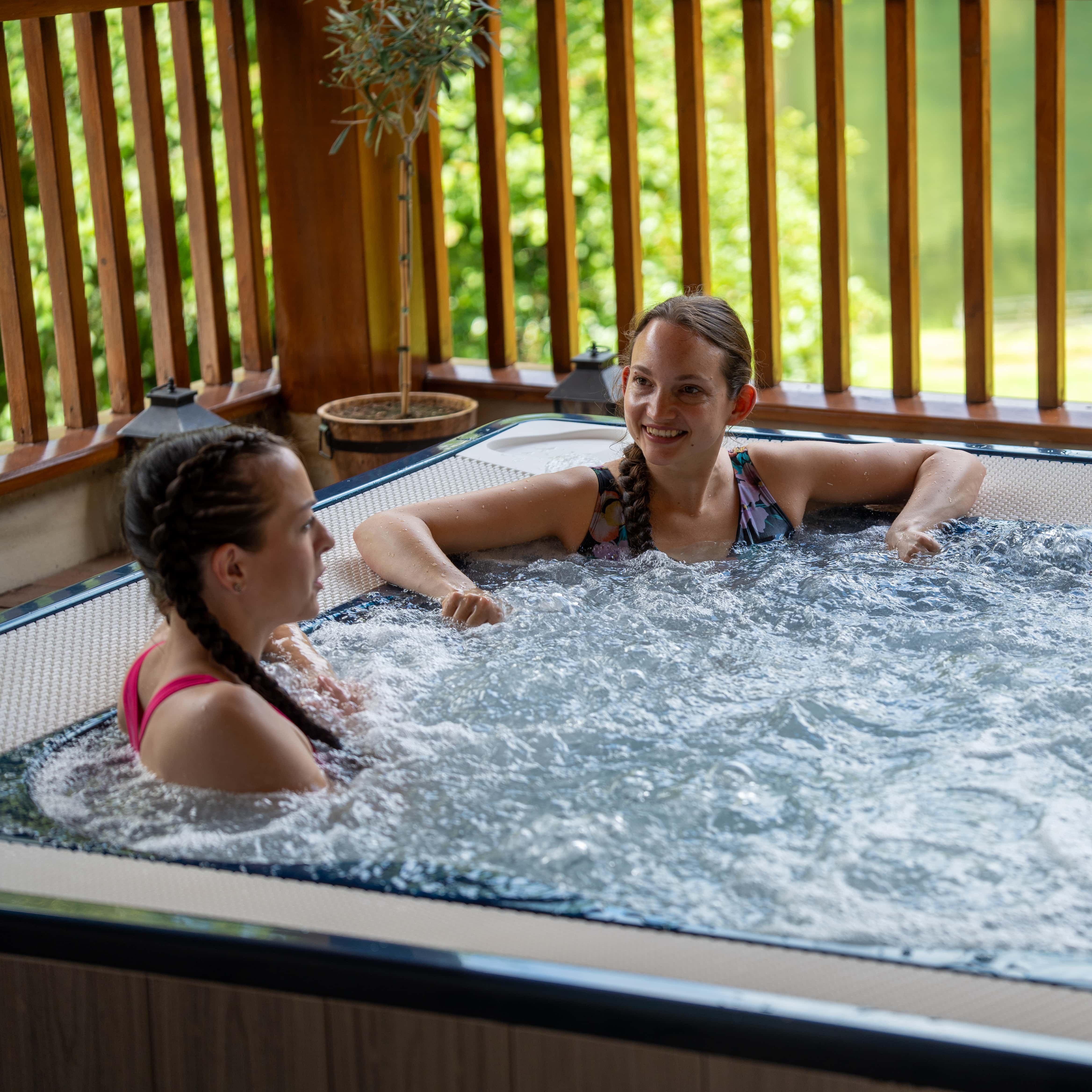 Three ladies laughing together in a hot tub