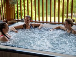 Three ladies laughing together in a hot tub
