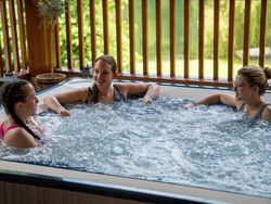 Three ladies laughing together in a hot tub