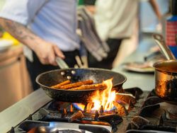 Chef frying food on flaming grill